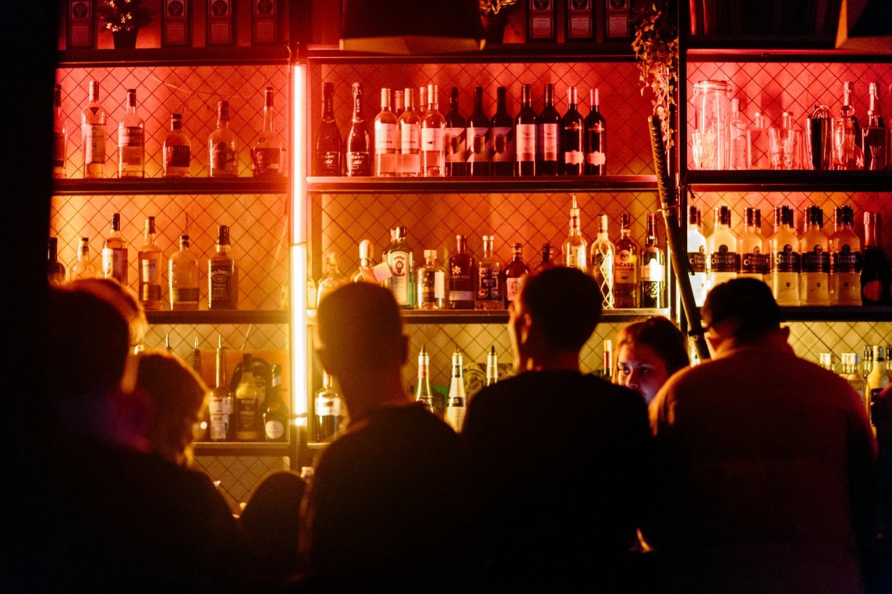 bar lit up surrounded by people