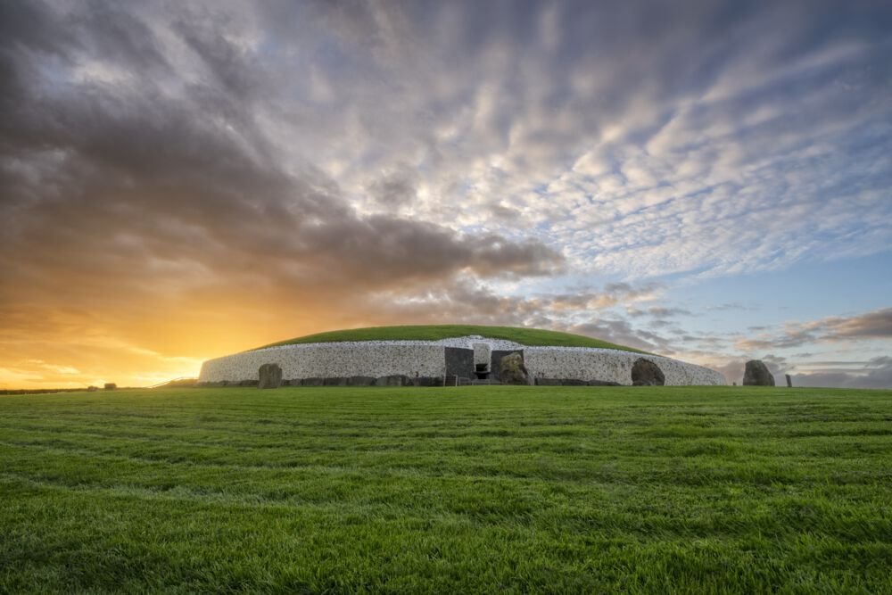 Image of a Stone Age Tomb surrounded by green grass